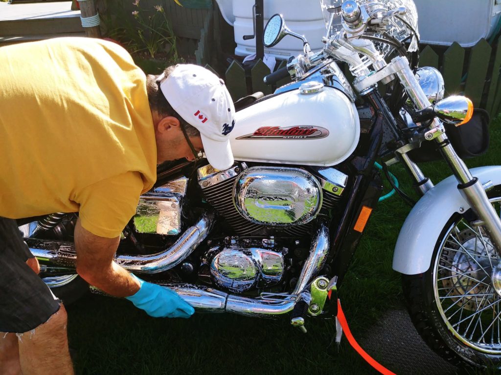 Silicone gloves shining the chrome of a motor bike.